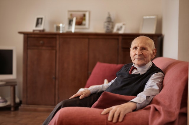 Elderly Man Sitting On Sofa